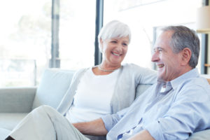 Shot of a happy senior couple talking while relaxing on their sofa at home