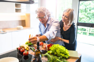 busy mature couple cooking in the kitchen